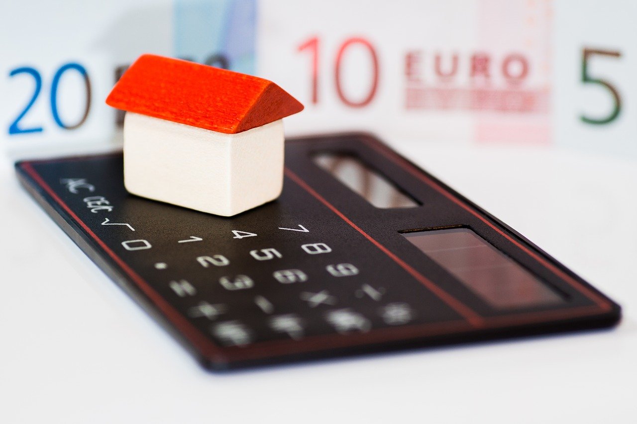 Kleines Haus auf Taschenrechner als Symbolbild für Hausverkauf