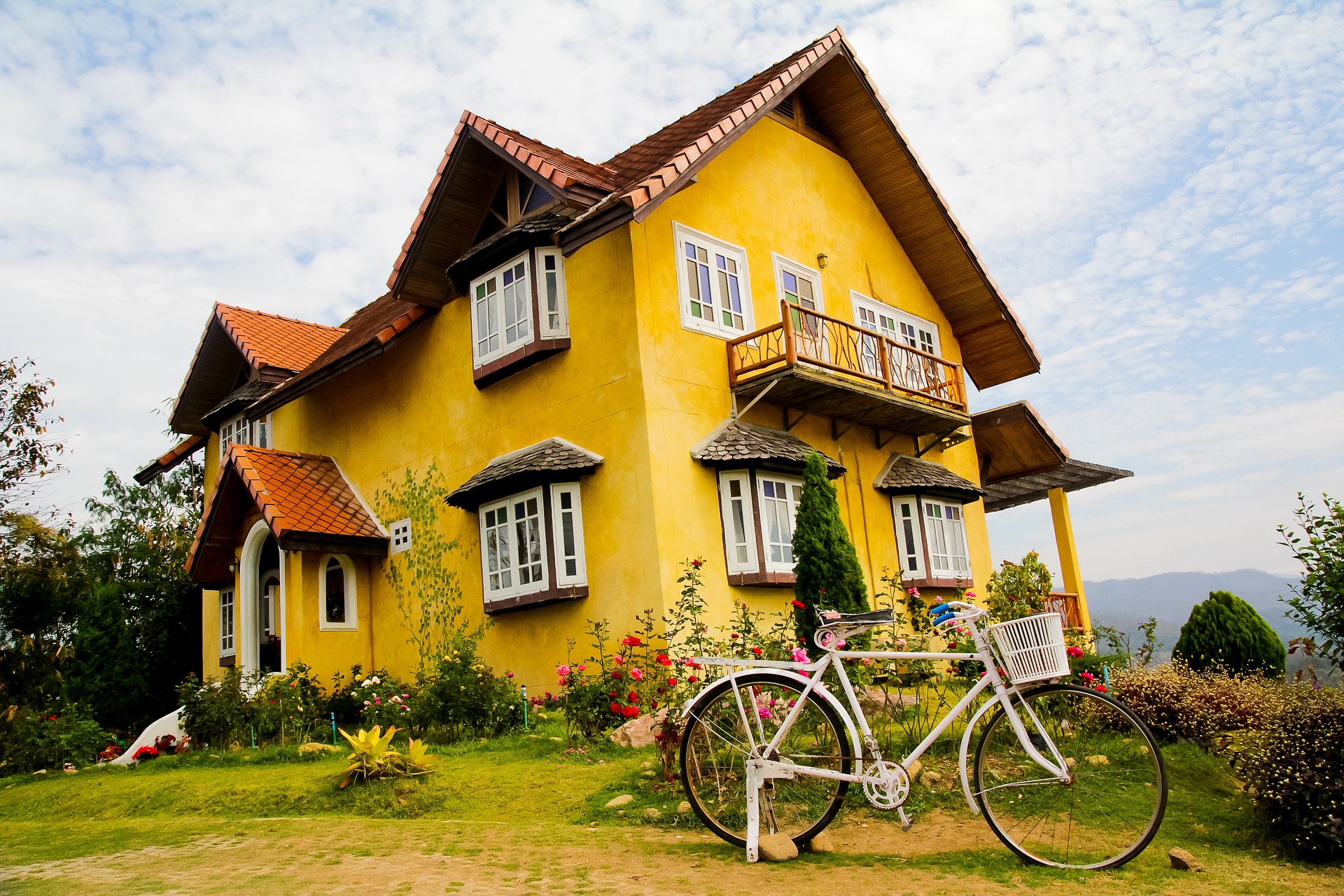 Wohnhaus mit gelber Fassade, im Vordergrund steht ein Fahrrad.