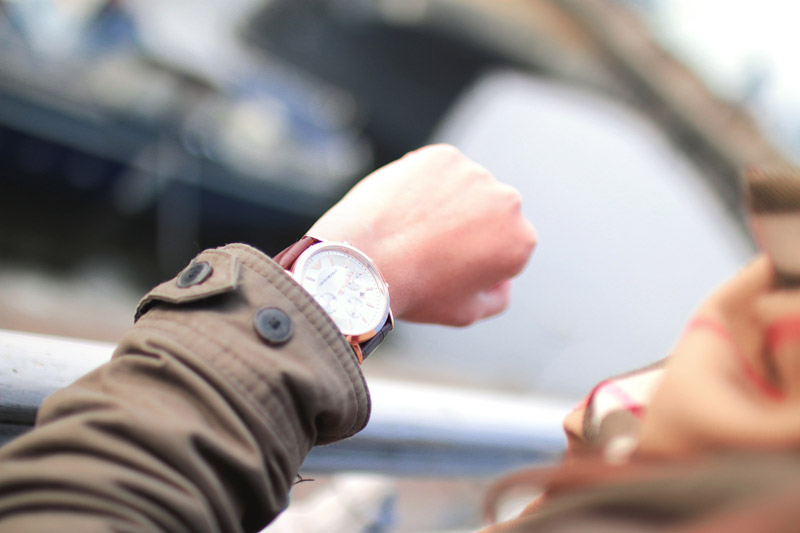 Blick auf die Armbanduhr als Symbolbild für Zeitdruck